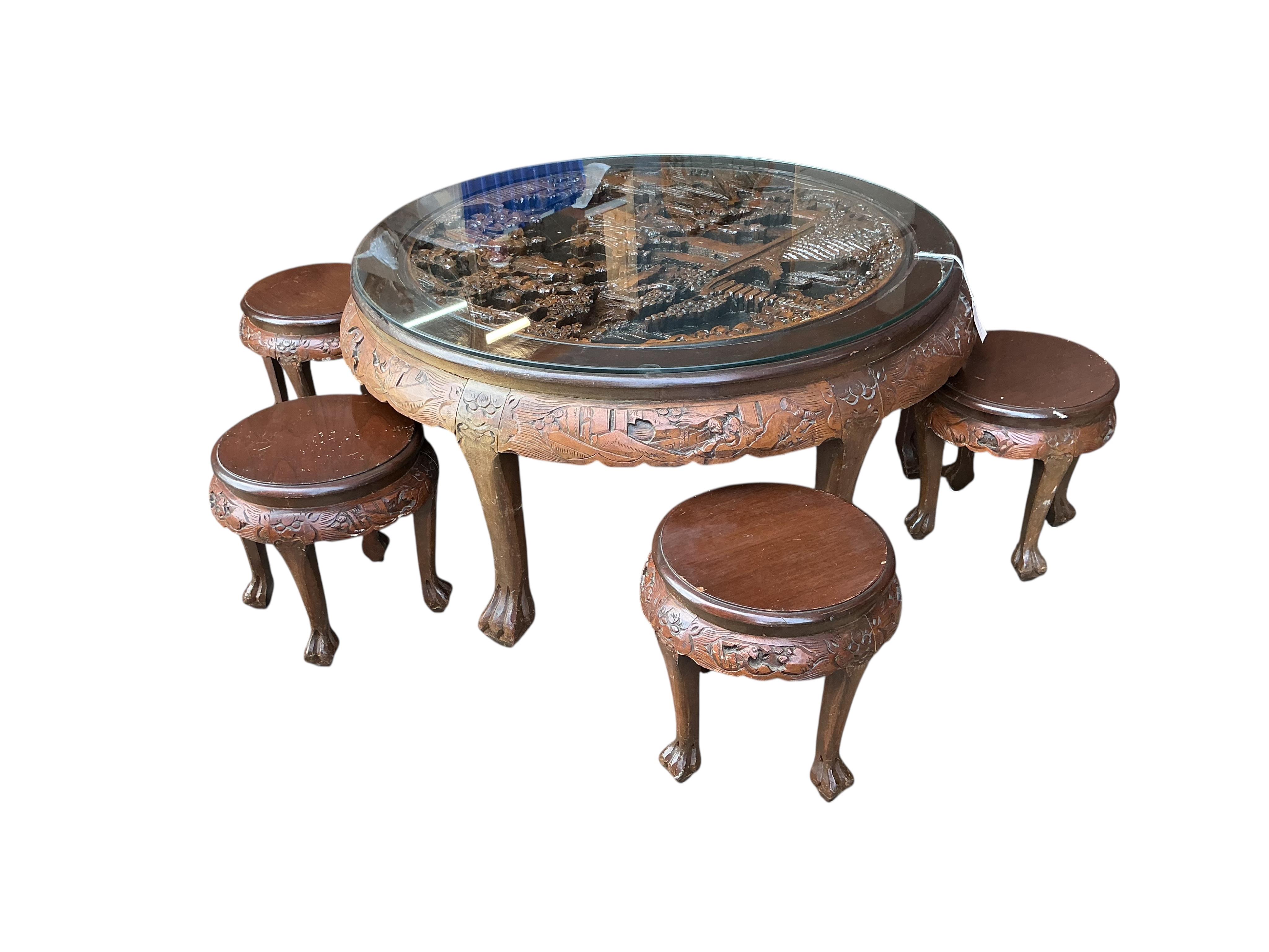 A Chinese carved hardwood circular low table, diameter 110cm, height 50cm and five stools
